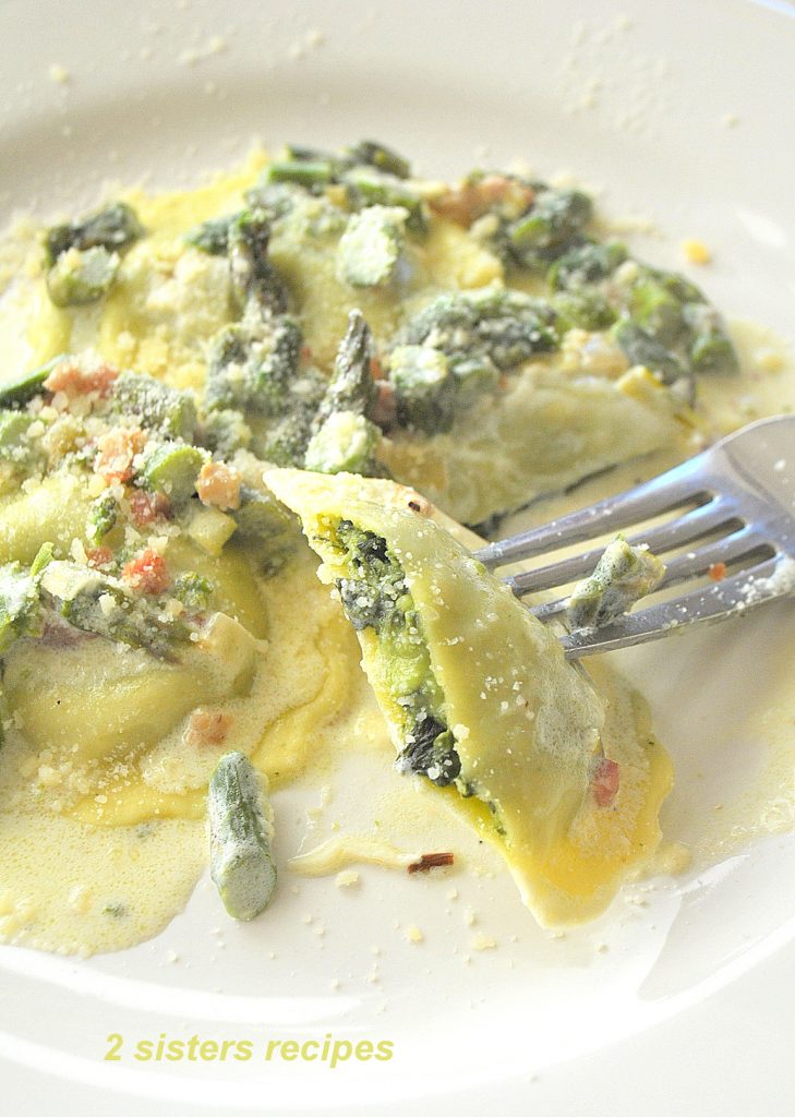 A Forkful of ravioli on a white plate. by 2sistersrecipes.com