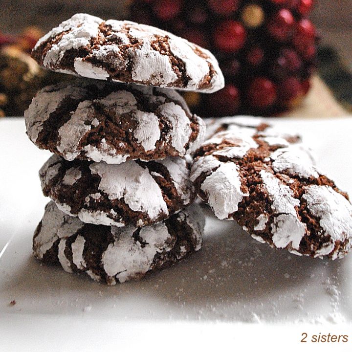 A pile of Chocolate Crinkle Cookies set on a white plate.