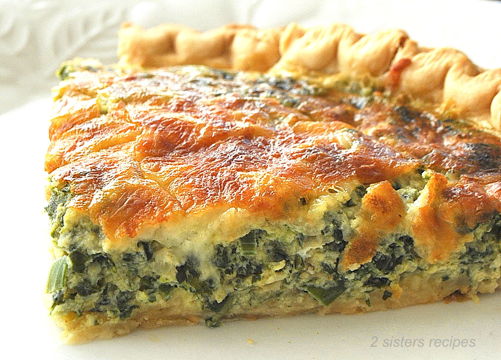 A slice of a baked golden pie loaded with a spinach and cheese mixture.