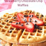 Round shape waffles with mini chocolate chips and sliced strawberries on top.