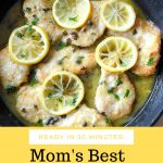 A black skillet filled with cooked chicken cutlets with capers and lemon slices.