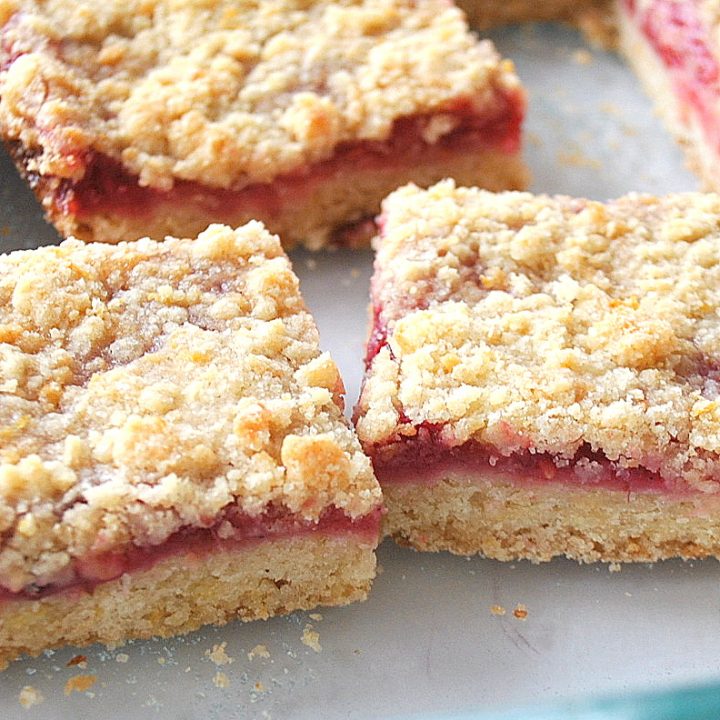 Raspberry bars are cut into squares inside its glass baking dish.