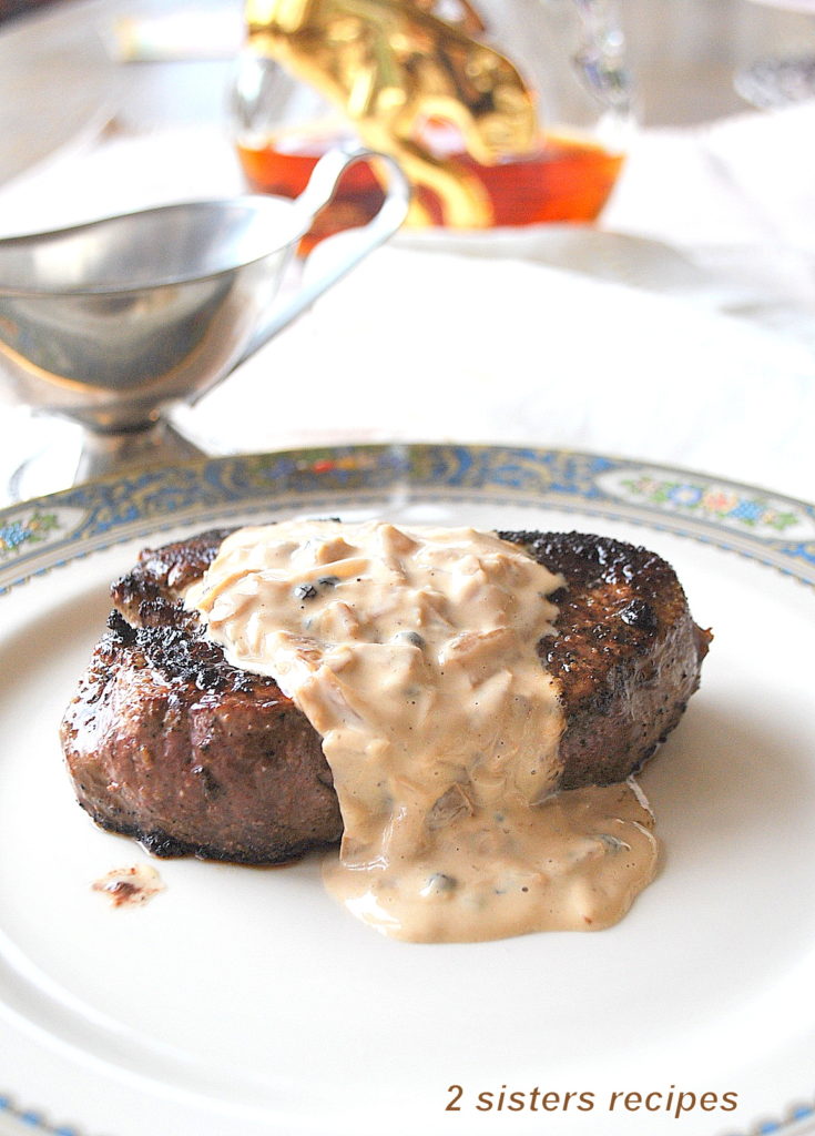 Filet Mignon with Cognac Peppercorn Sauce served on a white dinner plate.