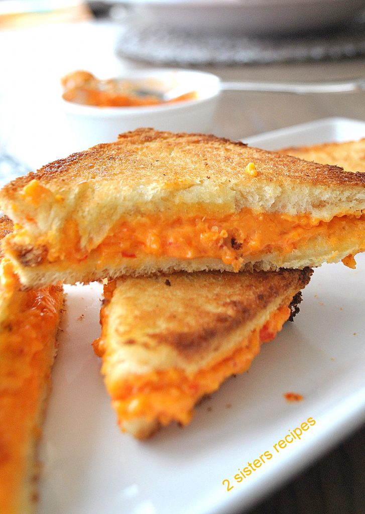 Grilled Pimento Cheese Sandwiches served cut into triangles pieces.