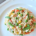 A white dinner plate filled with vegetable mixed risotto.