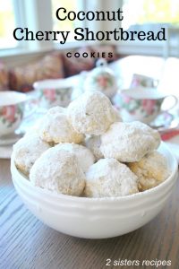 A white bowl filled with white powdered balls of cookies.