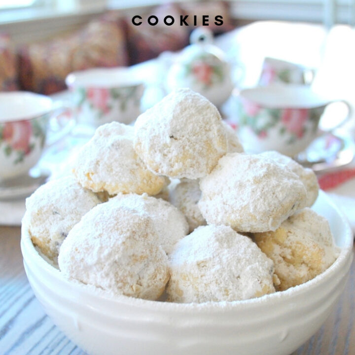 A white bowl filled with white powdered balls of cookies.