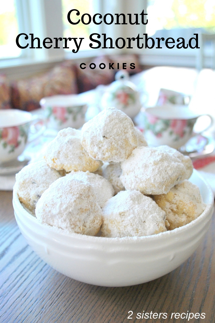 A white bowl filled with white powdered balls of cookies.