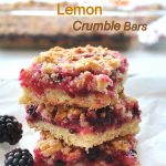 A pile of Blackberry Lemon Crumble Bars with fresh blackberries on the side.