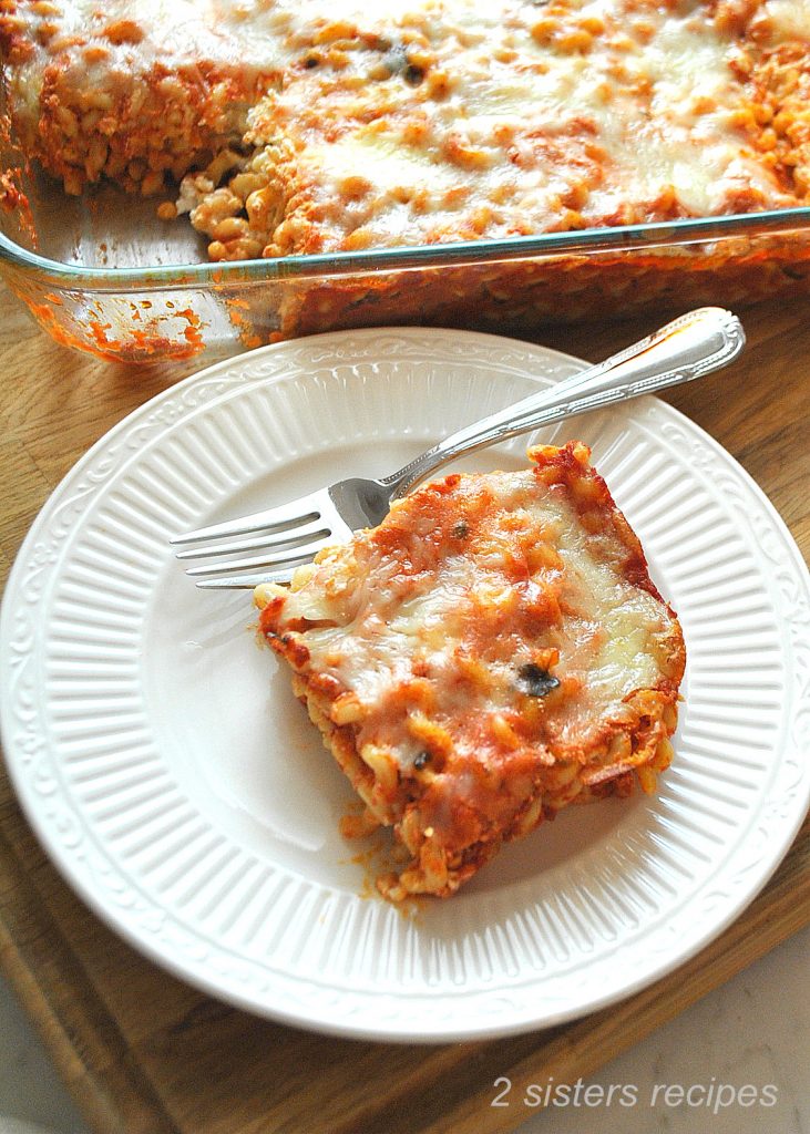 A piece of baked spaghetti served on a white plate with a fork by 2sistersrecipes.com