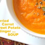 Curried Carrot and Sweet Potato Ginger Soup served in a white bowl.