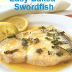 A baked swordfish served on a white plate with lemon sauce.