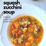 A white bowl filled with a colorful soup made with chunks of butternut squash, zucchini, carrots and celery.