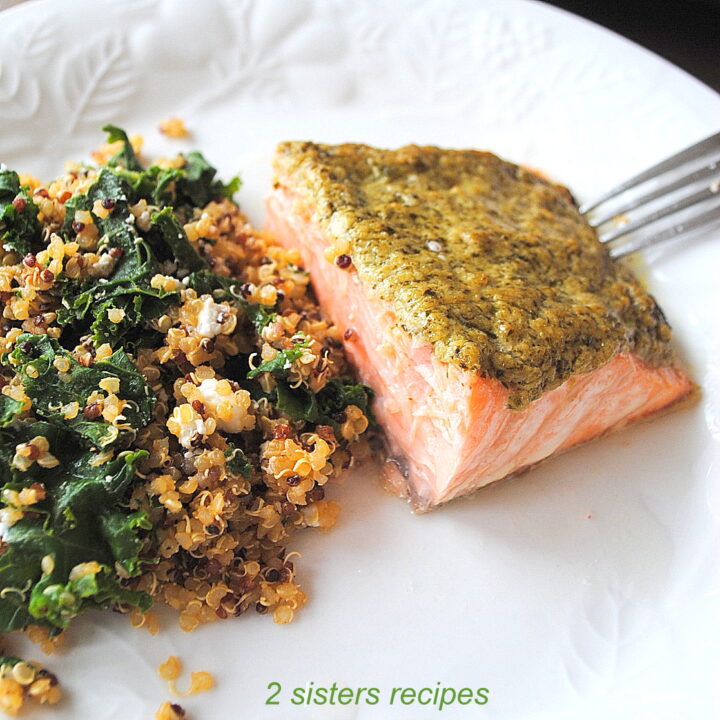 A serving on a white dinner plate with Baked Salmon and a quinoa salad on the side.