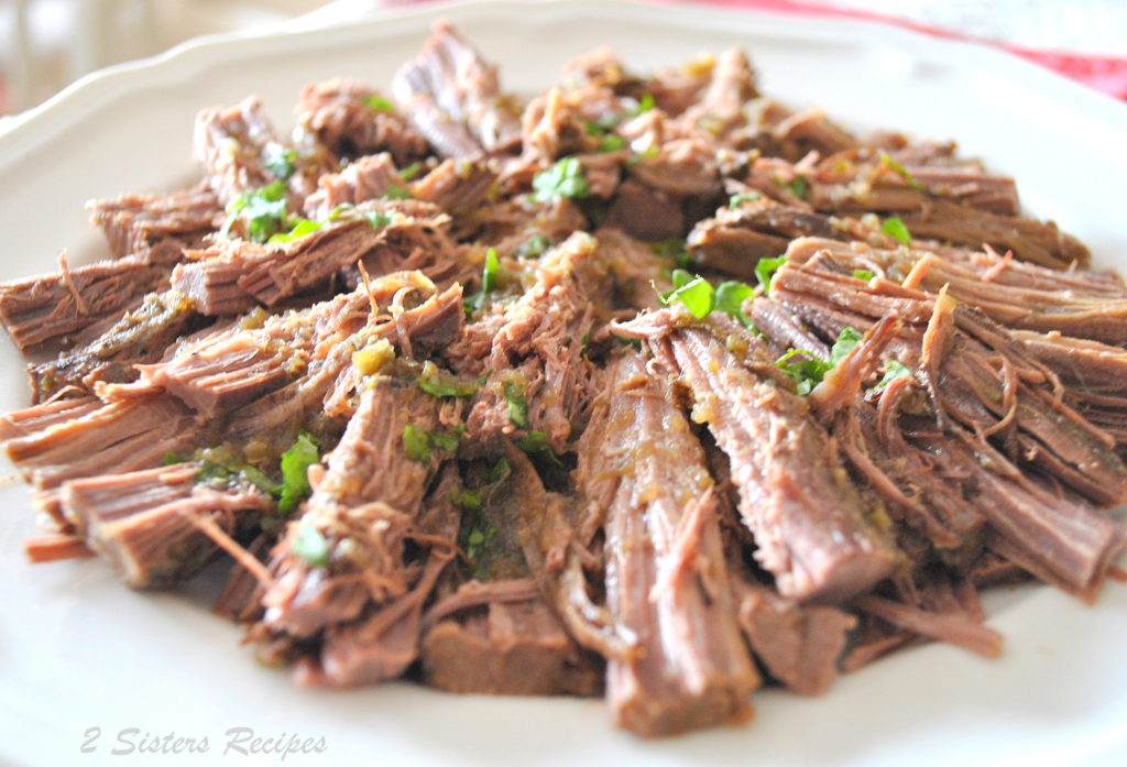 A platter filled with sliced brisket topped with some parsley.