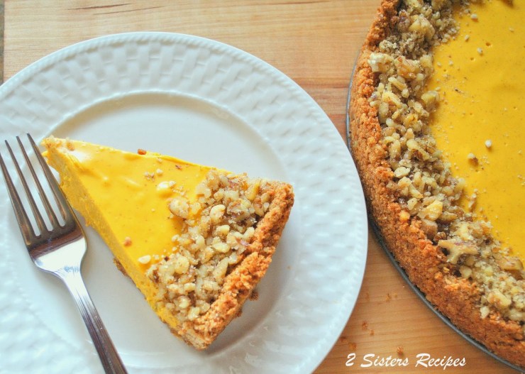 A slice of Pumpkin Cheesecake on a plate. by 2sistersrecipes.com 