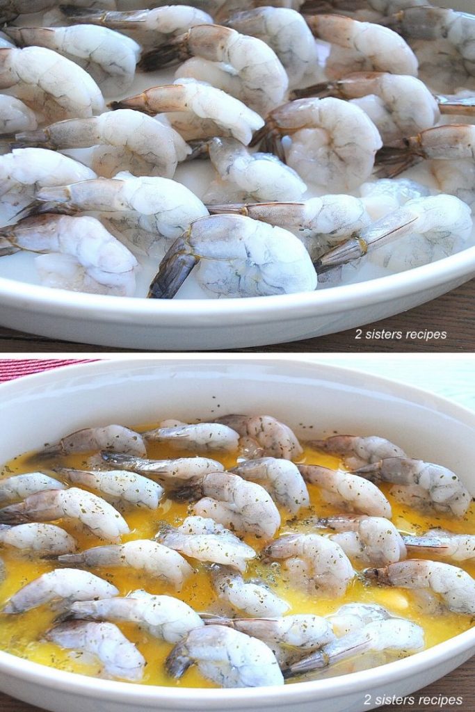 In a white baking dish, showing the shrimp smothered with butter sauce. by 2sistersrecipes.com