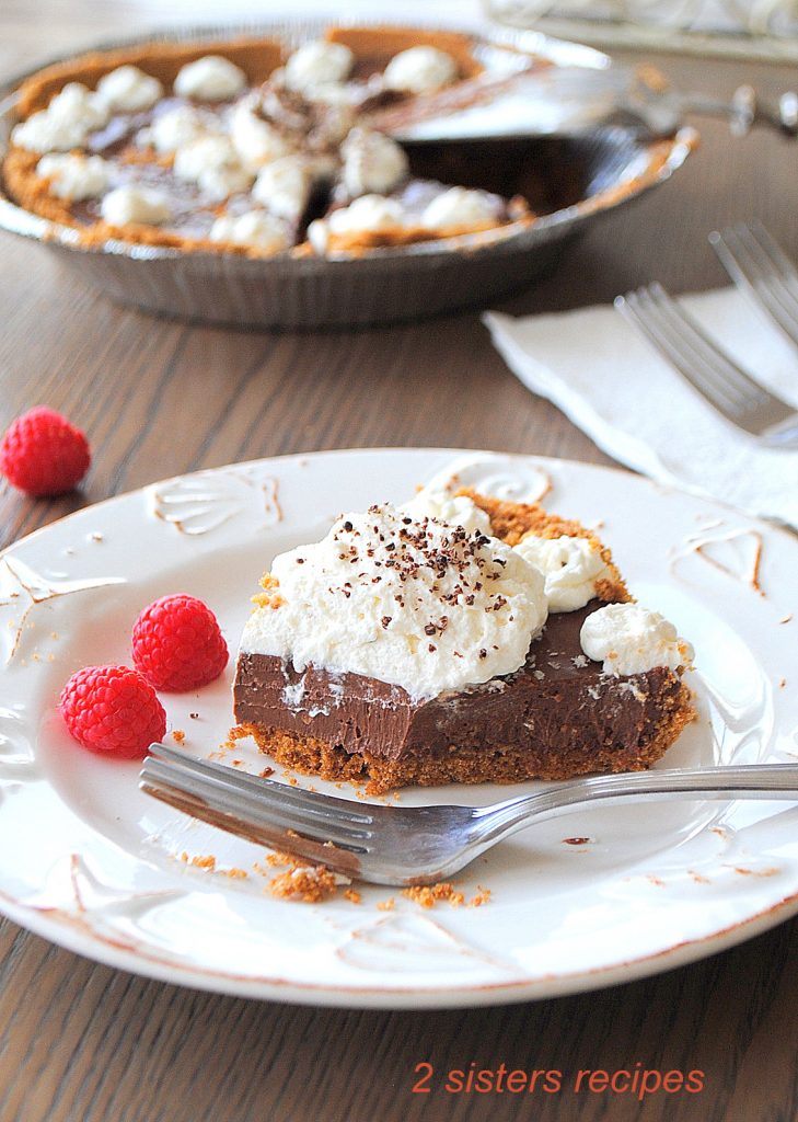 A slice of pie on a white plate. by 2sistesrecipes.com 