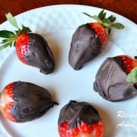 A white plate with chocolate covered strawberries.