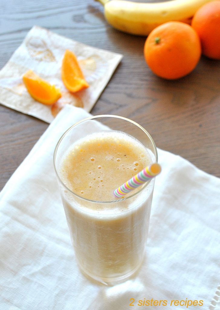 Healthier Orange Creamsicle Smoothie  served in a tall glass with a straw.