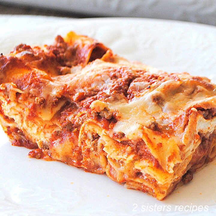 A serving of a lasagna on a white plate.