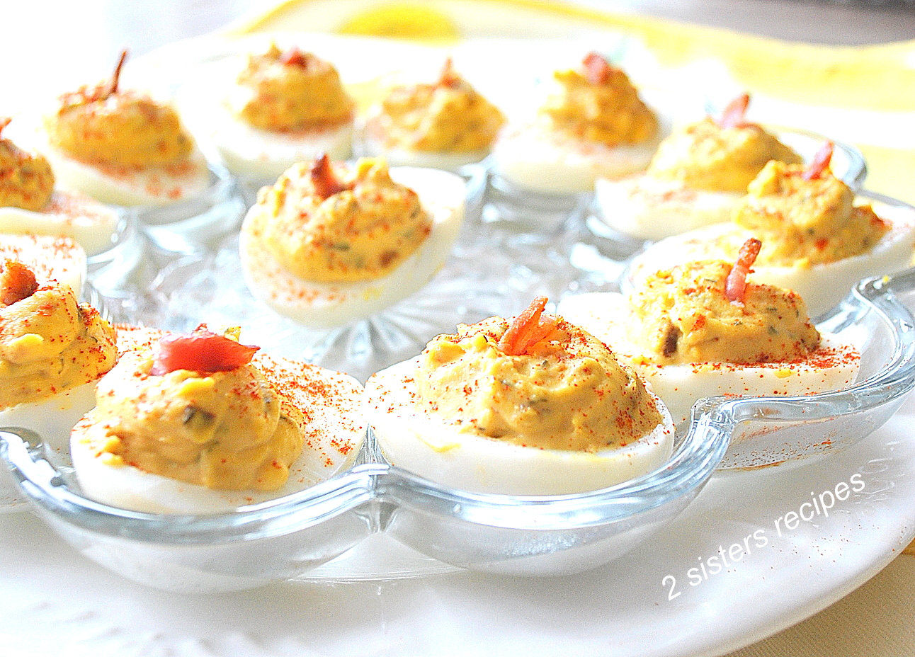 A glass plate filled with deviled eggs ready to be served.