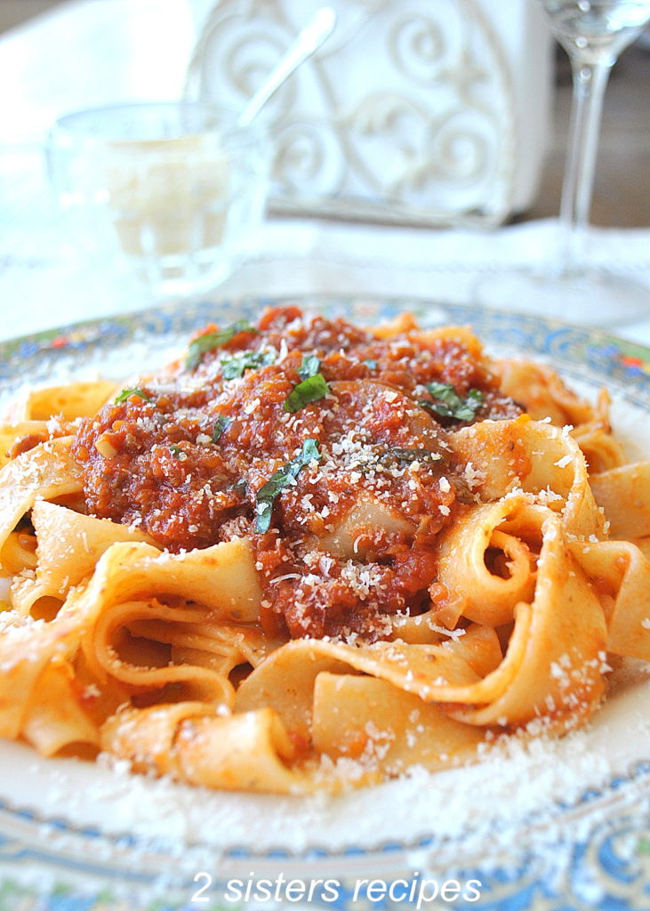 A close up of Vegetable Bolognese with Pappardelle on a blue dinner plate. 