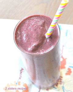Beet Spinach Protein Smoothie served in a tall glass with a colored striped straw.