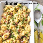 A white casserole dish filled with tortellini, peas, and bacon bits.