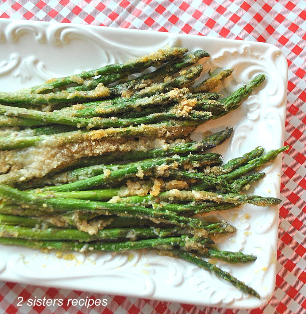 A white platter with roasted asparagus gratin.