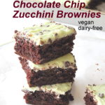 A pile of mint chocolate chip zucchini brownies served on a sheet of wax paper.