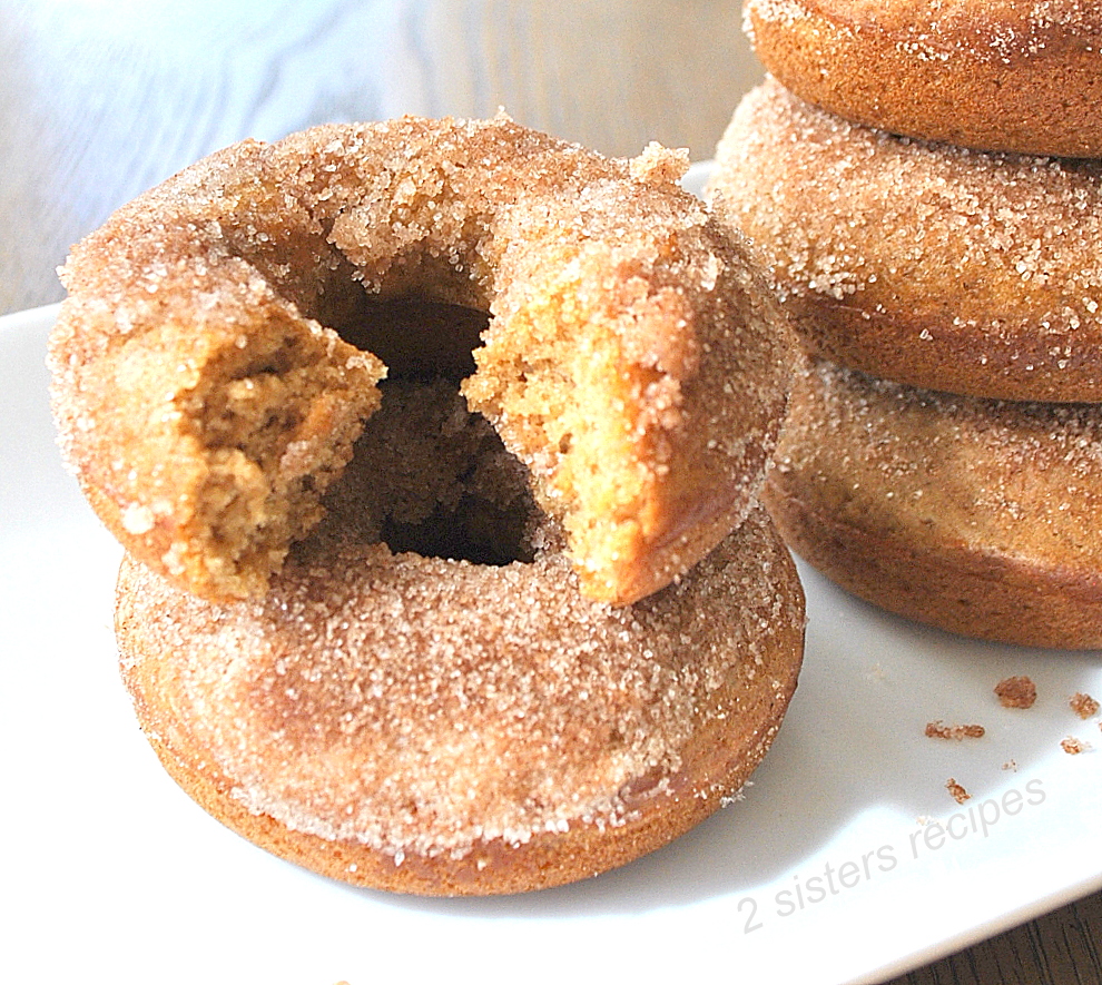 A bite out of a cinnamon apple cider donuts by 2sistersrecipes.com