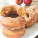 Donuts set on a serving platter, with a half of a donut on top of two.