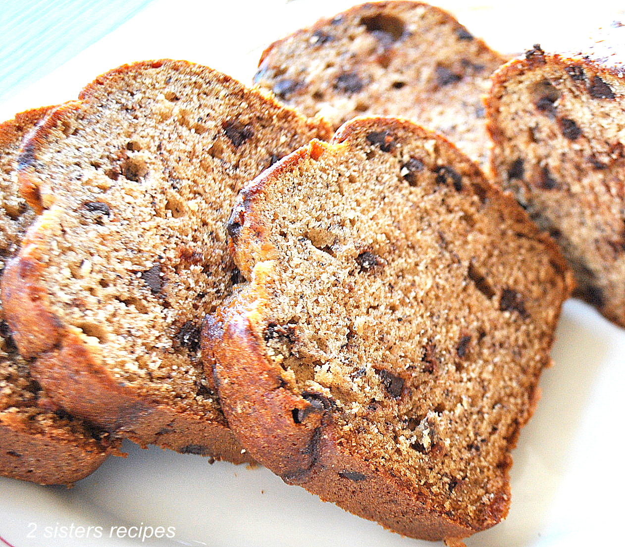 Slices of chocolate chip bread served on a white plate.