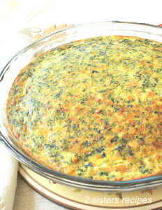 A glass pie dish filled with a baked quiche.