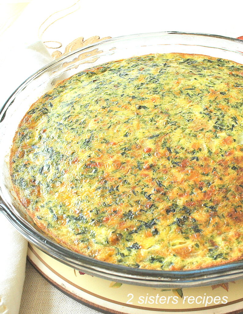 A glass pie dish filled with a baked quiche.