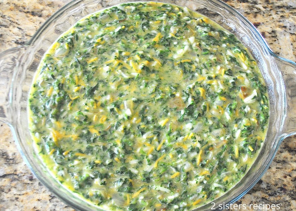 The spinach and cheese mixture is poured into a baking dish.