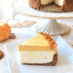 A slice of 2 layer pumpkin cheesecake served on a white plate.
