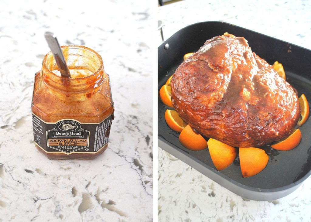 Photo with wedges of oranges around the ham, and a jar of glaze on the counter.