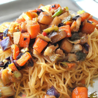 Capellini Pasta topped with stir-fry vegetables served on a silver platter.