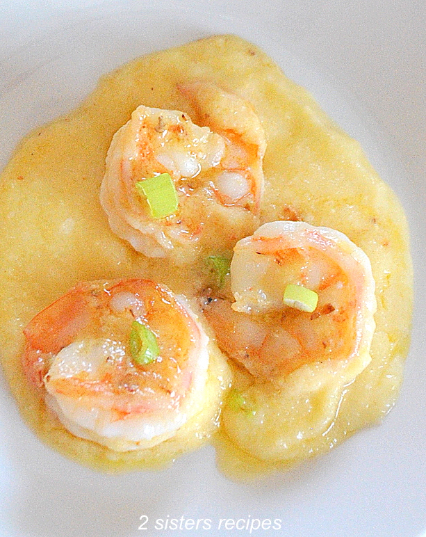 A photo of 3 shrimps on a plate over the polenta by 2sistersrecipes.com