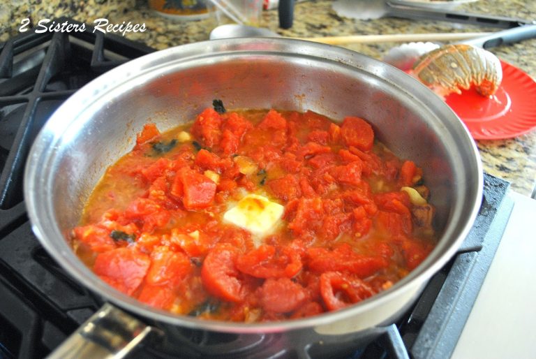 A sauce pot with fresh tomatoes simmering with butter melting in the center. by 2sistersrecipes.com 