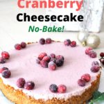 A cheesecake with a lovely pink color on top with sugar cranberries as garnish.