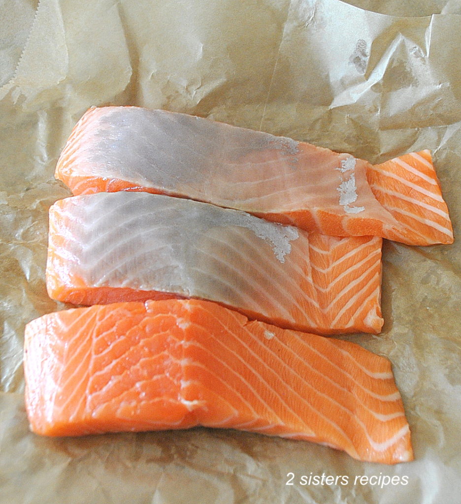 Raw salmon on brown paper by 2sistersrecipes.com