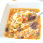 A spoonful of soup with mini pasta shells with beans and veggies,