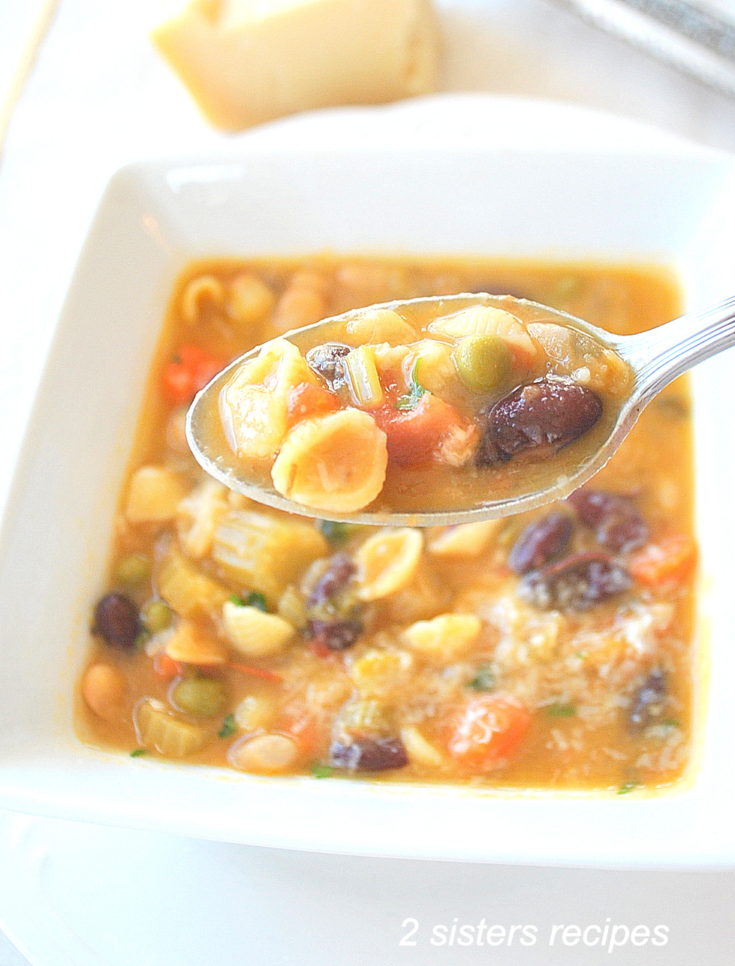 A spoonful of soup with mini pasta shells with beans and veggies,