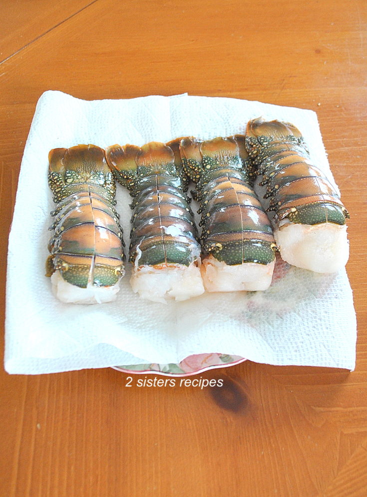 photo of 4 frozen lobster tails on paper towels. by 2sistersrecipes.com