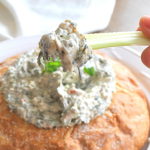 A celery stick with a dollop of Spinach Dip on it.