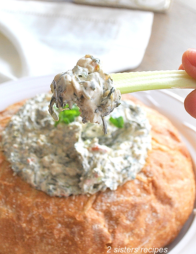 A celery stick with a dollop of Spinach Dip on it.  