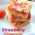 A pile of strawberry pineapple bars served on a white plate, with a fresh strawberry on the side.